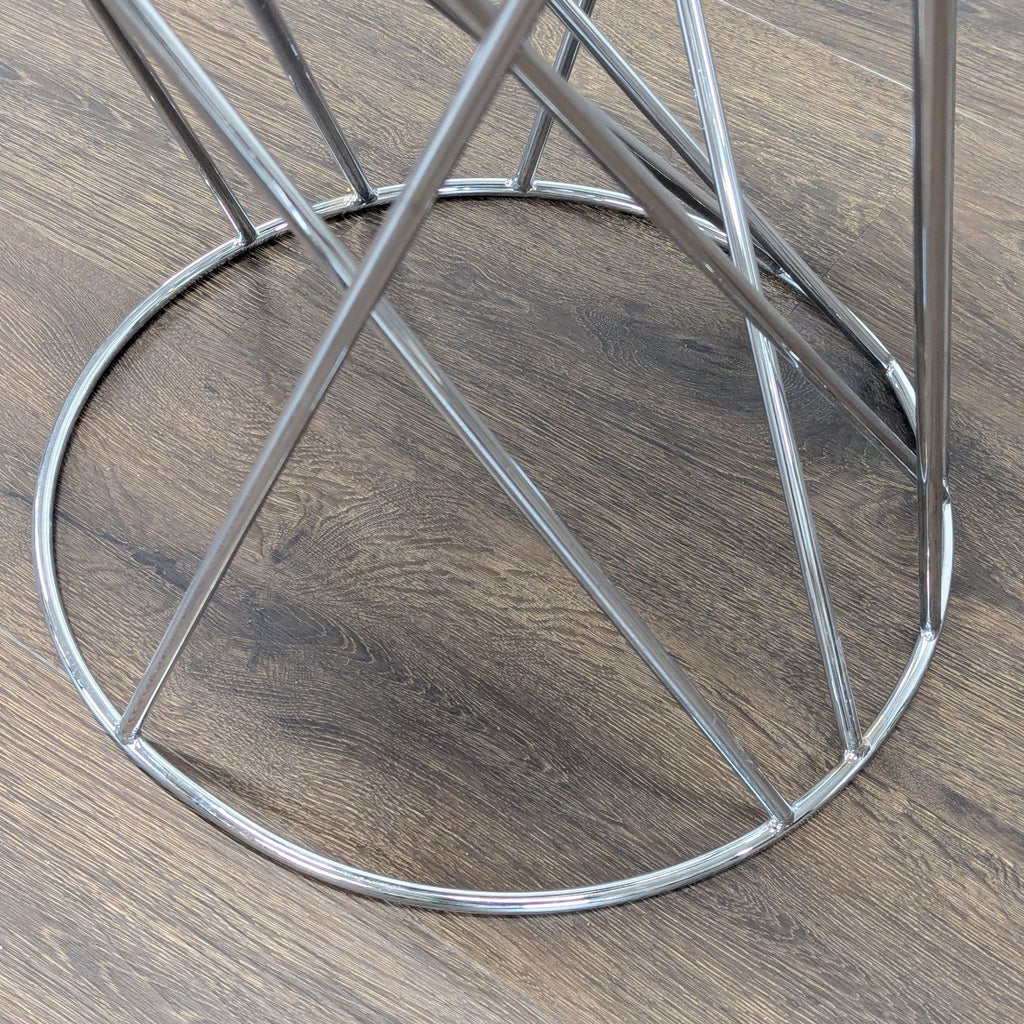 2. Close-up of the chrome wire geometric base of a West Elm side table, showing intersecting lines.