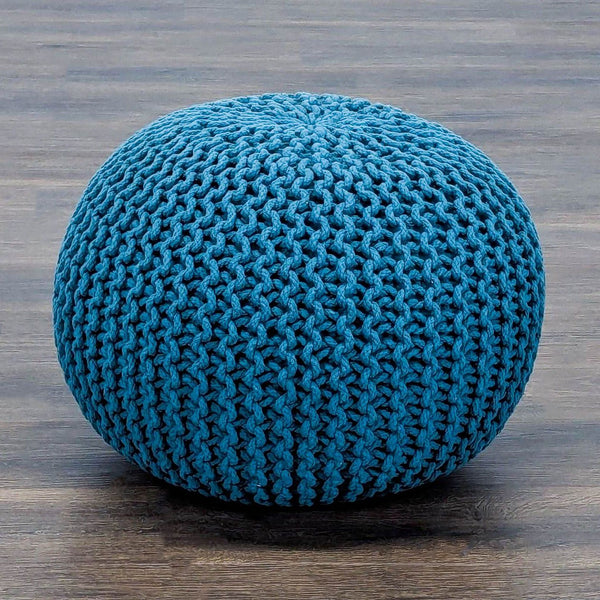 1. Round blue knitted pouf ottoman by Reperch, shown on wooden floor, ideal for modern seating or decor.