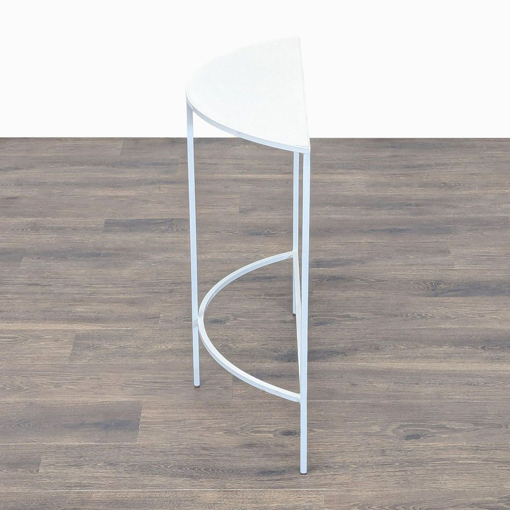 3. Sleek Reperch side table with a white curved top, slender legs, and simple construction, viewed from the side.