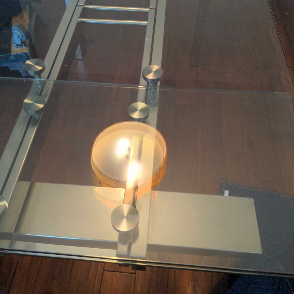 2. Close-up of a glass coffee table top, showcasing metal supports and a reflected ceiling light fixture.  