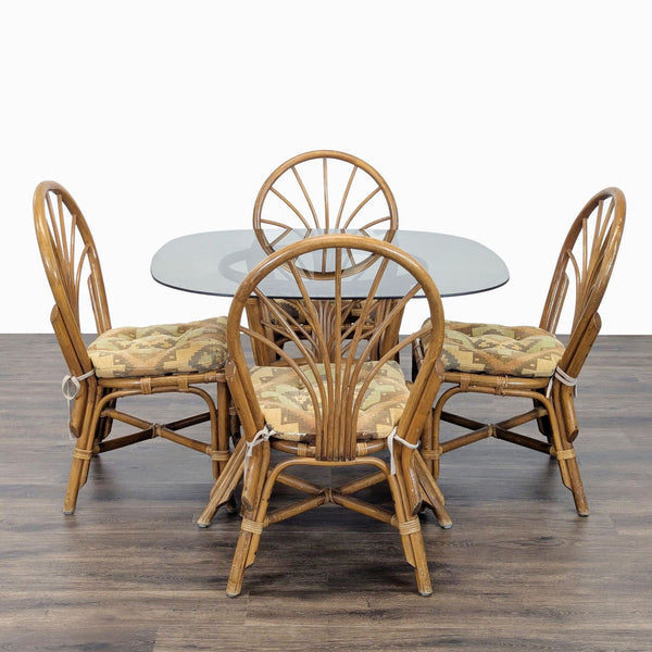 1. Dining set by Reperch featuring a rattan table with glass top and four cushioned rattan chairs.