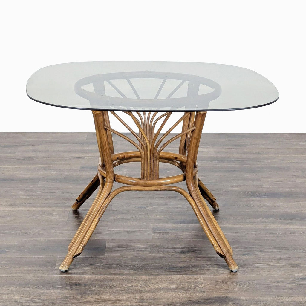 2. Closeup of Reperch dining set’s rattan table with a sturdy, clear glass top and natural finish.