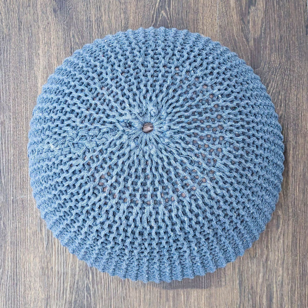 3. Top view of a round blue knitted stool by Reperch, featuring a textured pattern and central detail.
