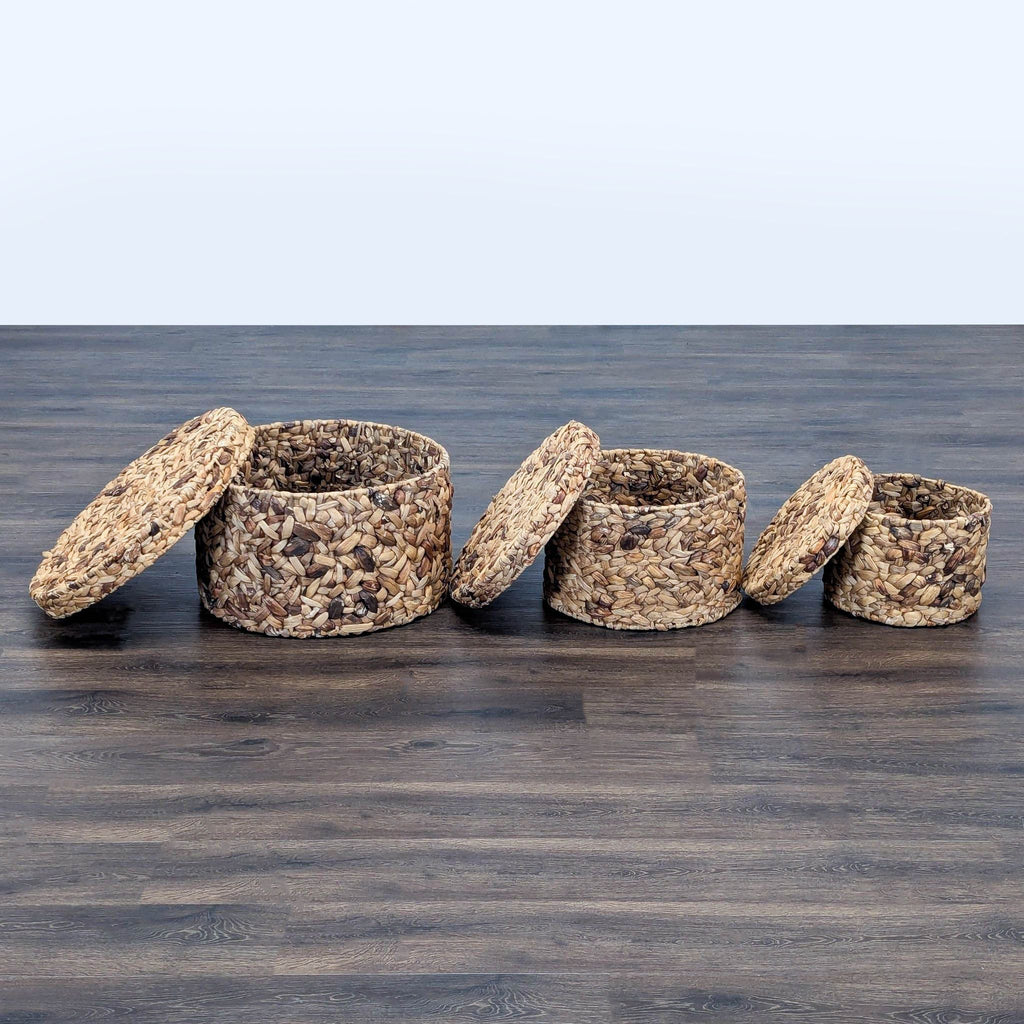 1. Three round woven Reperch baskets with lids, displayed open on a dark wooden floor.