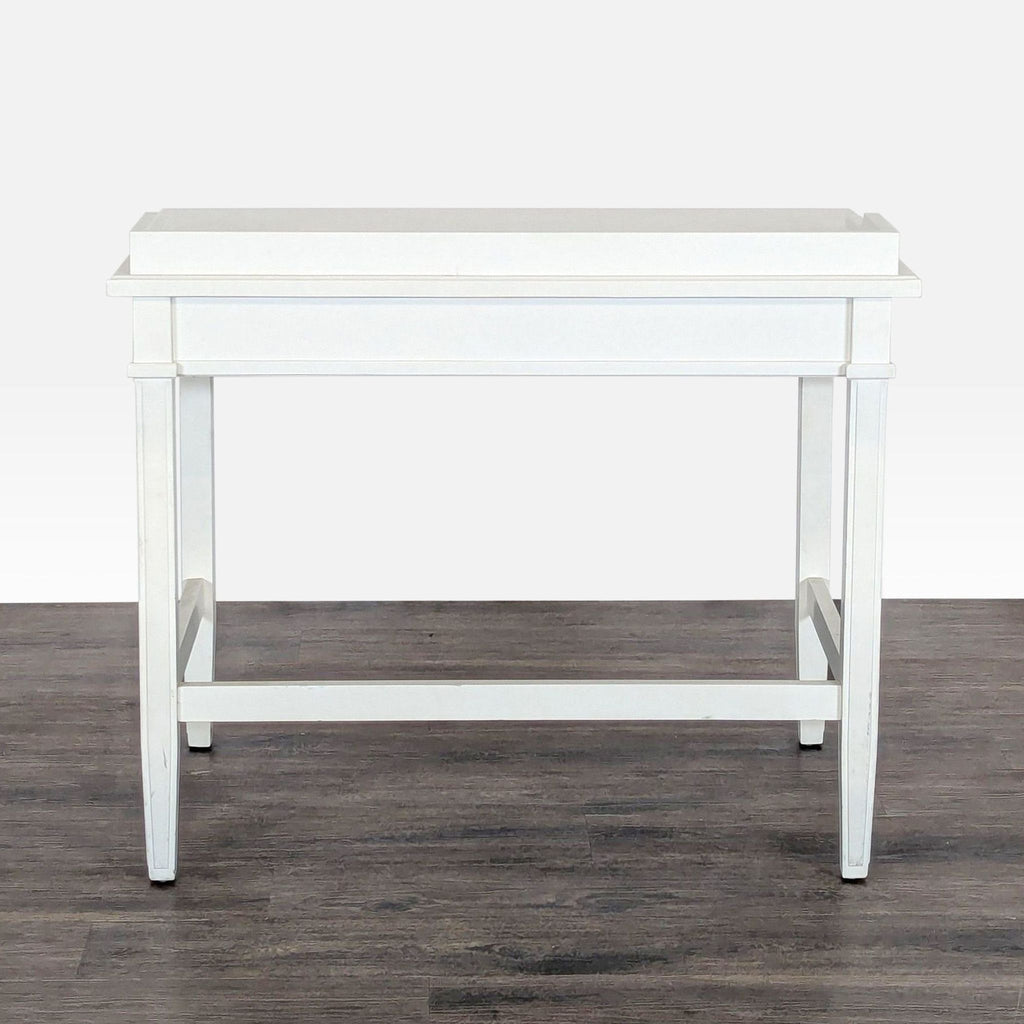 3. Front view of a Crate & Barrel white desk on dark wood flooring, highlighting its minimalist rectangular shape.