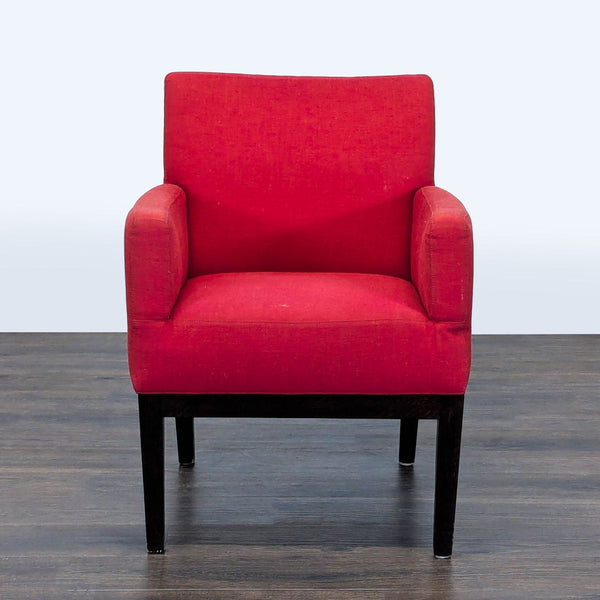 1. Front view of a Reperch lounge chair with red upholstery and dark wooden legs, on a wooden floor.