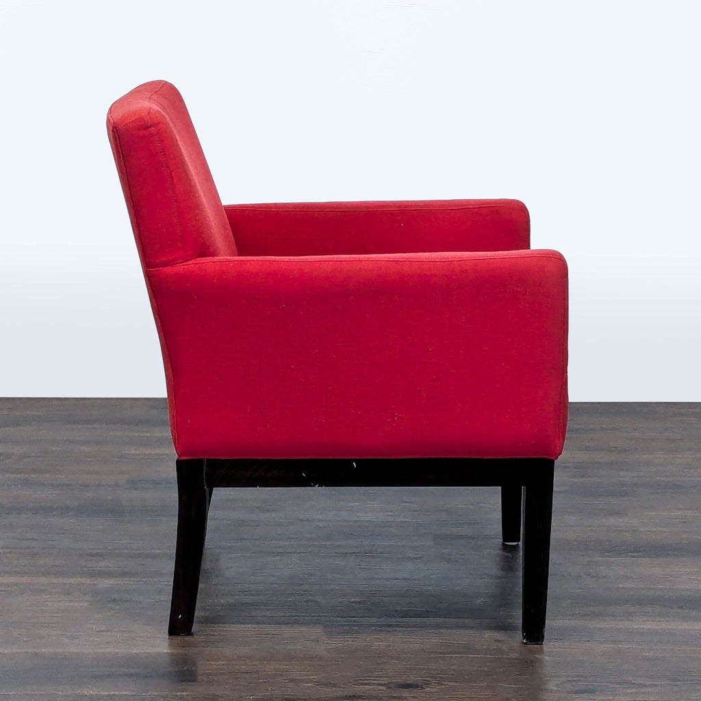 3. Side profile of a red Reperch lounge chair, showing armrests and dark wooden frame on flooring.