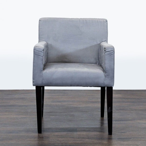 1. Front view of a gray lounge chair by West Elm with a boxy design and black wooden legs on a wooden floor.  
