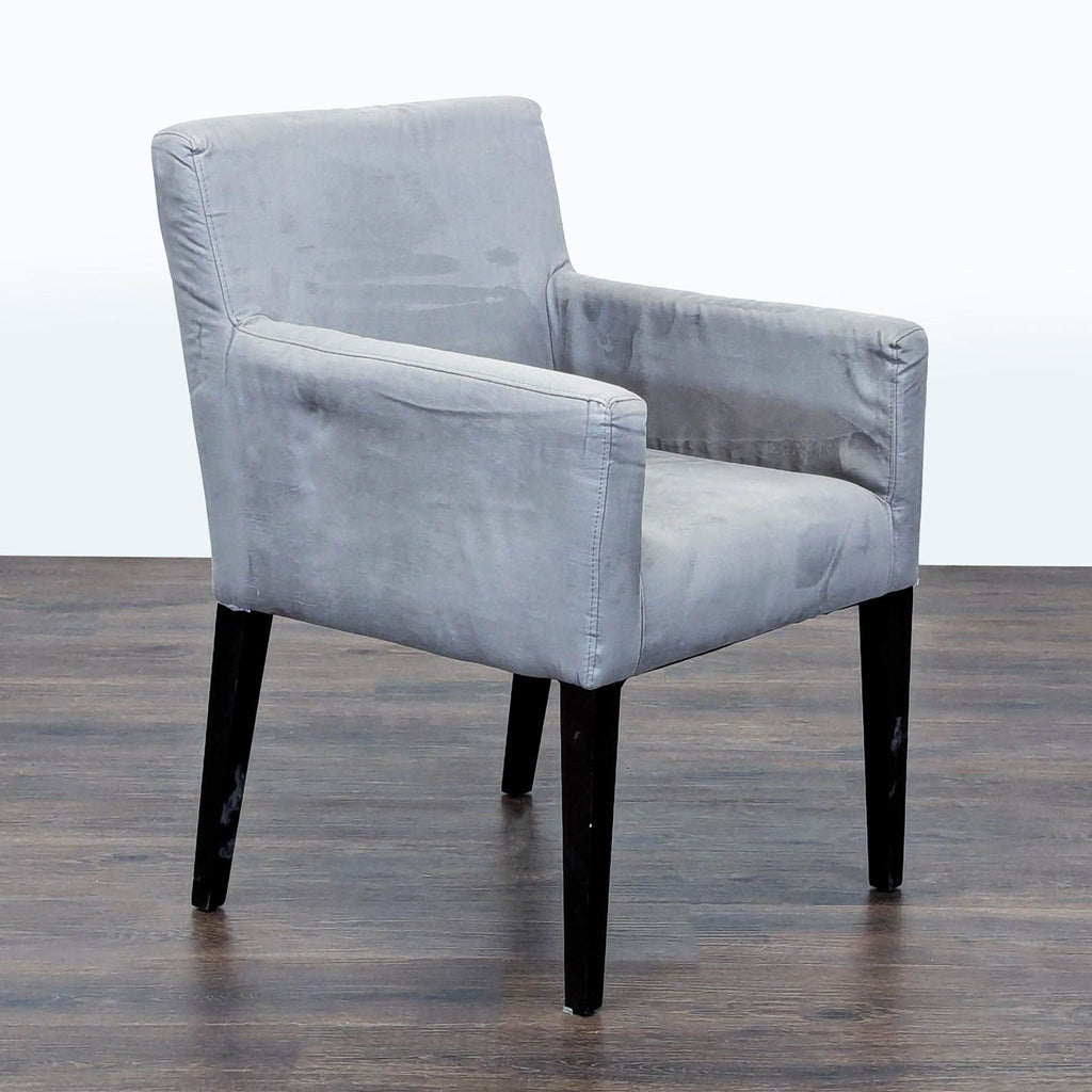 2. Angled side view of a West Elm lounge chair in gray fabric, with padded arms and dark wood legs.  