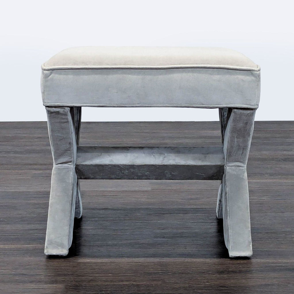 2. Front view of a West Elm gray velvet ottoman, highlighting the rectangular seat and sturdy legs.