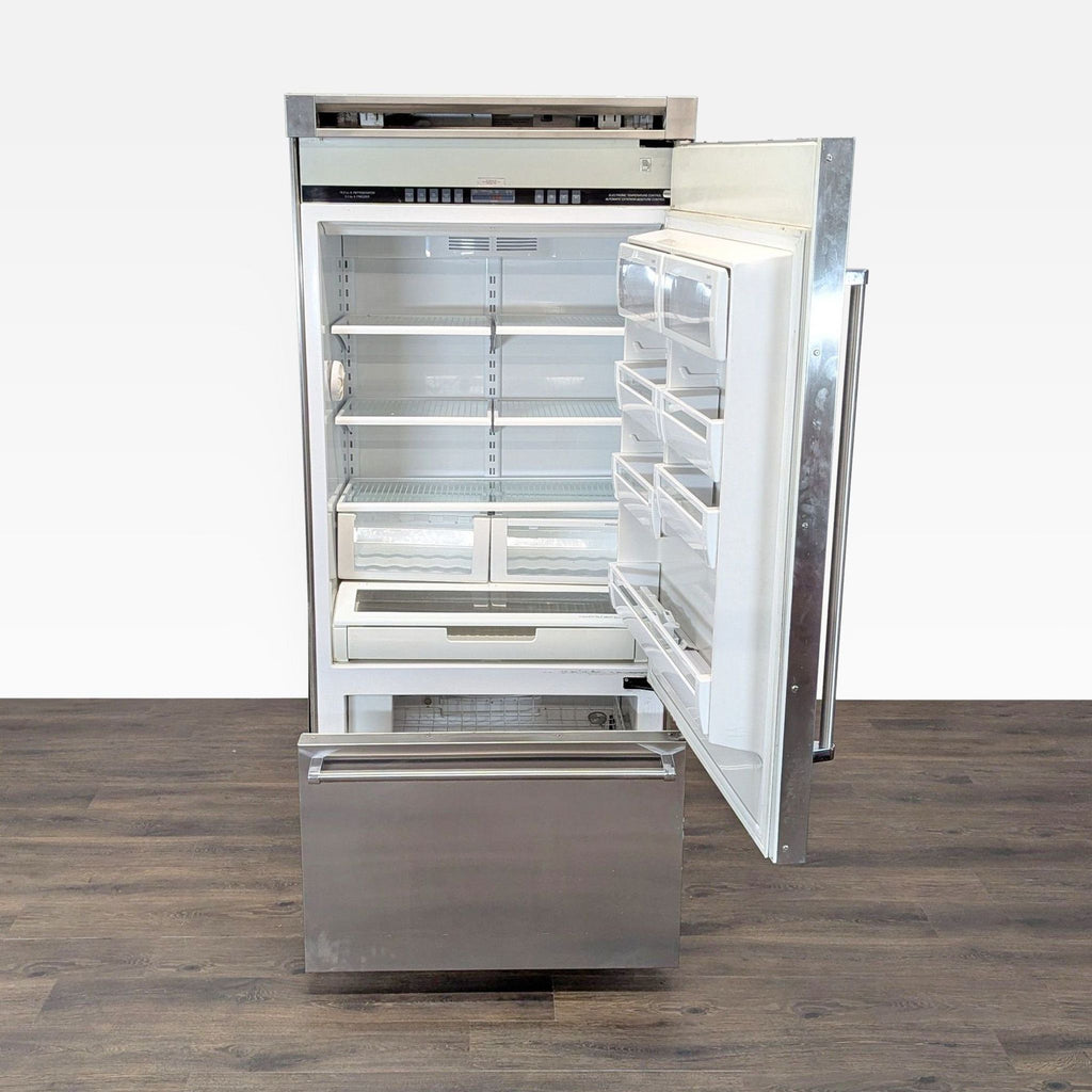 Open Viking Professional refrigerator showing adjustable shelves, door bins, and two produce crispers above the bottom freezer.