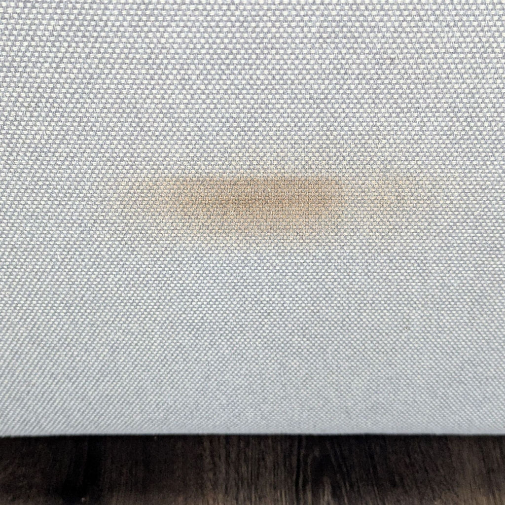 3. Detail of a visible brownish stain on the lower side of the BluDot 3-seat sofa fabric.