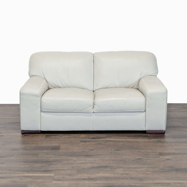 1. Cream leather Reperch loveseat with wide arms, plush cushions, and stable wood feet, shown from the front.