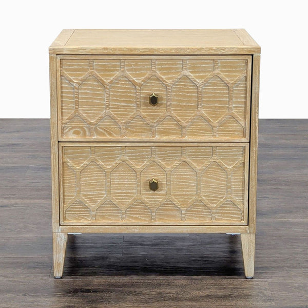1. Front view of a Reperch end table with two drawers and geometric carved details on light wood.