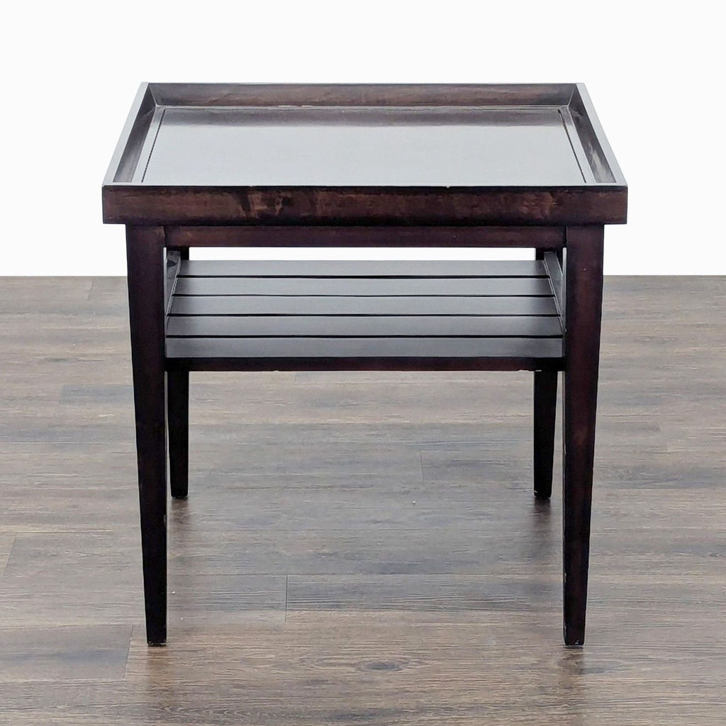 3. Front view of Reperch end table in dark wood, featuring a slatted lower shelf and square raised edge top.