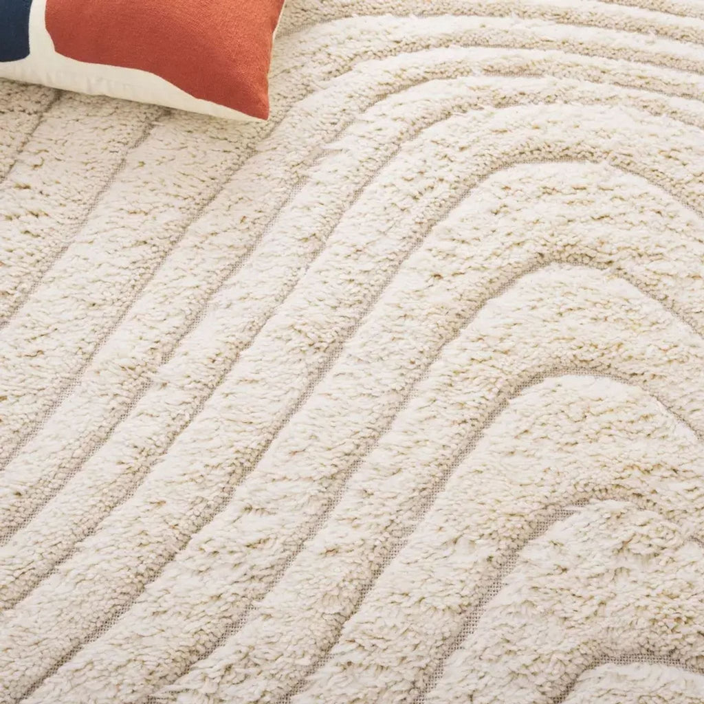3. Detailed view of the Havenly brand rug's raised wavy lines and plush texture, partially shown with a pillow.