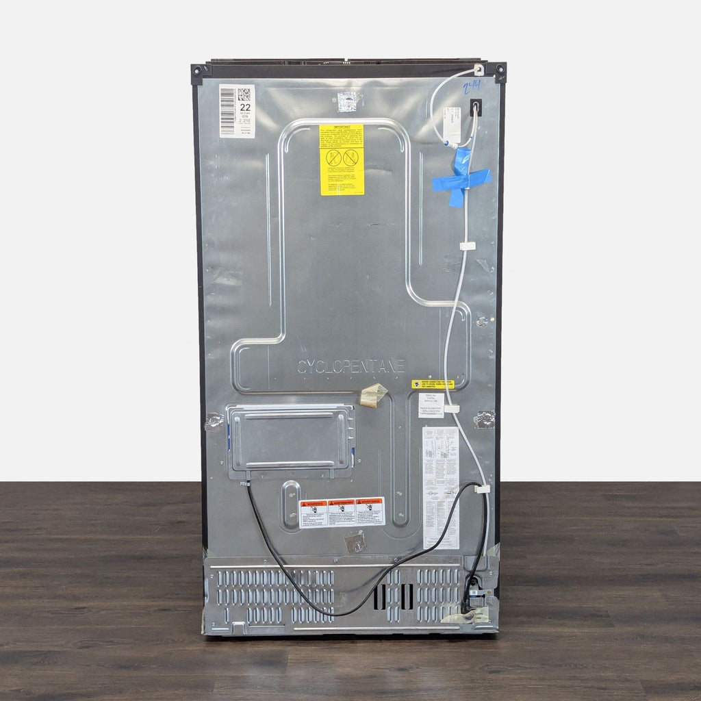 3. Rear view of a GE French door refrigerator with visible power cord and back panel details on a wood floor.