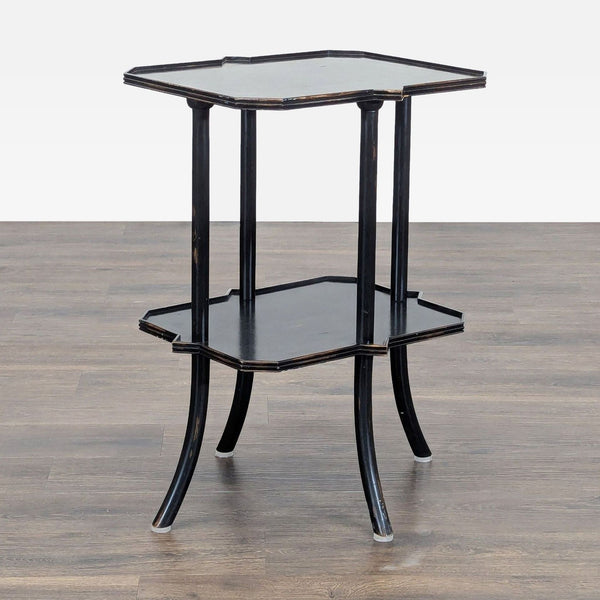 1. Black two-tier Reperch side table with curved legs and scalloped edges, on a wood floor background.