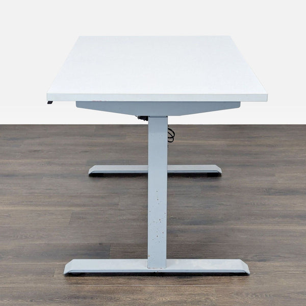 1. Front view of a Reperch brand standing desk with a white tabletop and silver T-shaped metal base.