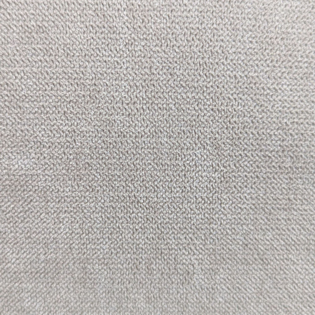 Macro view of the textured light beige upholstery fabric from a Living Spaces 3-seat sofa.