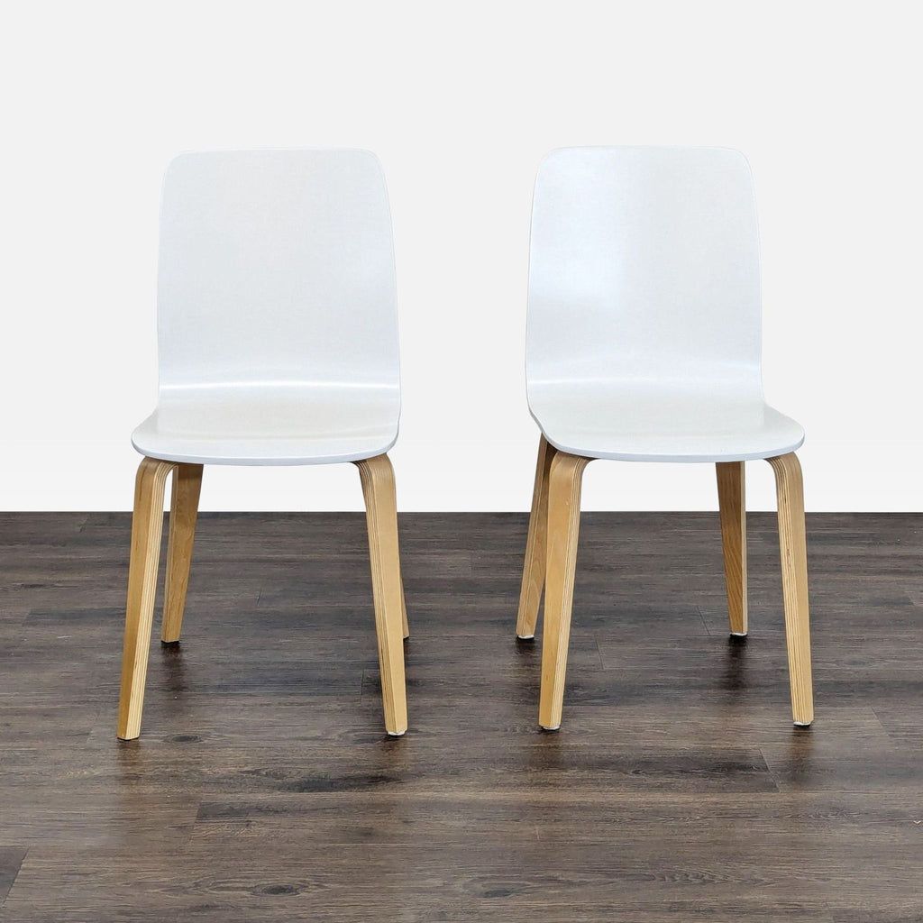 1. Pair of Anthropologie dining chairs with clear lacquer finish, white seats, and natural wood legs, front view.