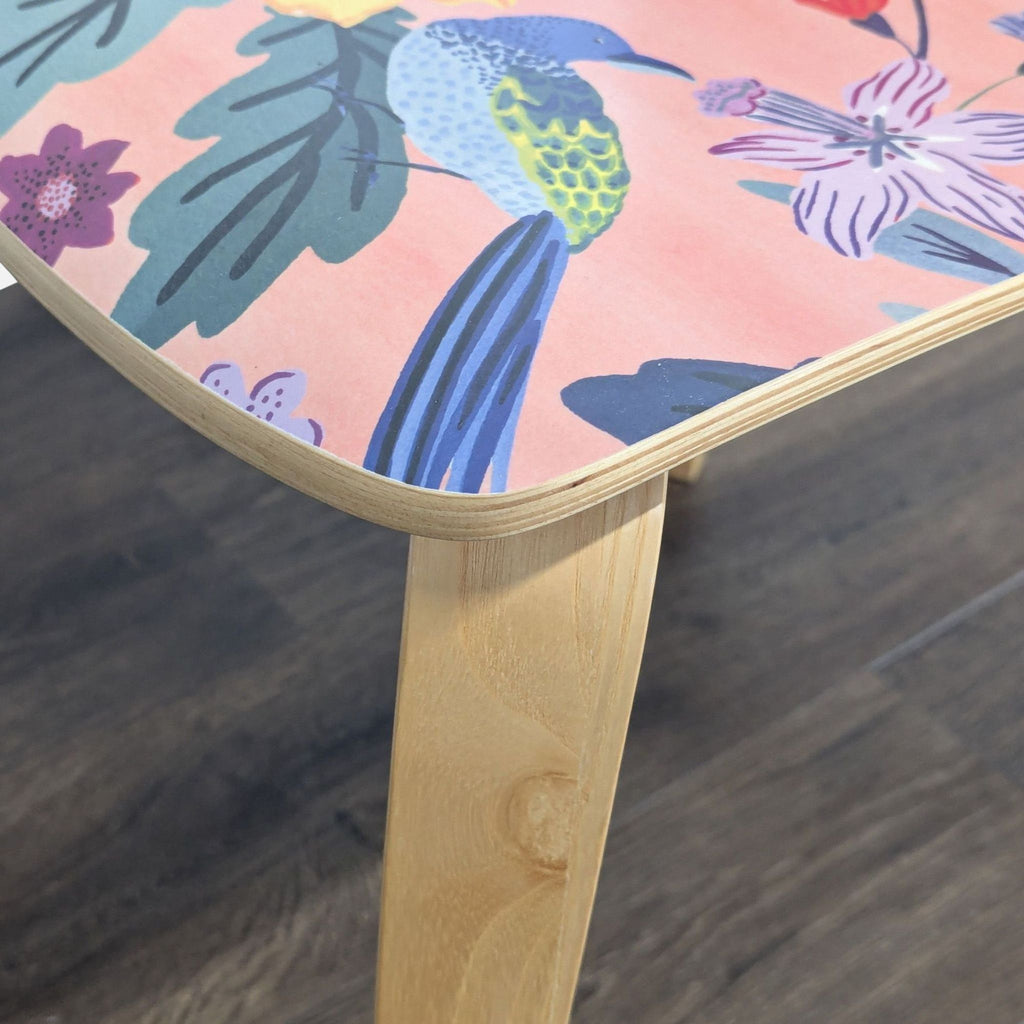 3. Close-up of an Anthropologie dining chair seat showing detailed floral and bird patterns over bentwood.
