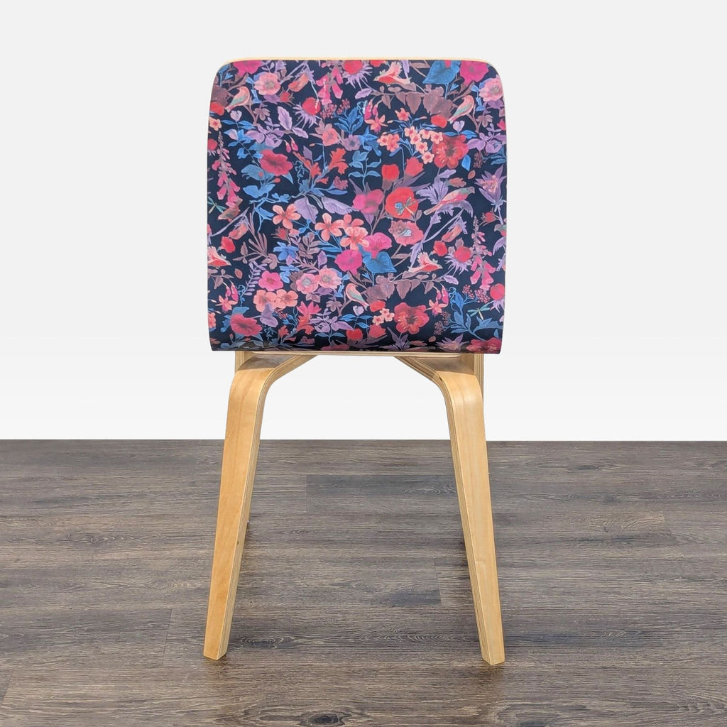 2. Rear view of an Anthropologie dining chair; bentwood design, clear lacquer finish, and all-over floral seat pattern.