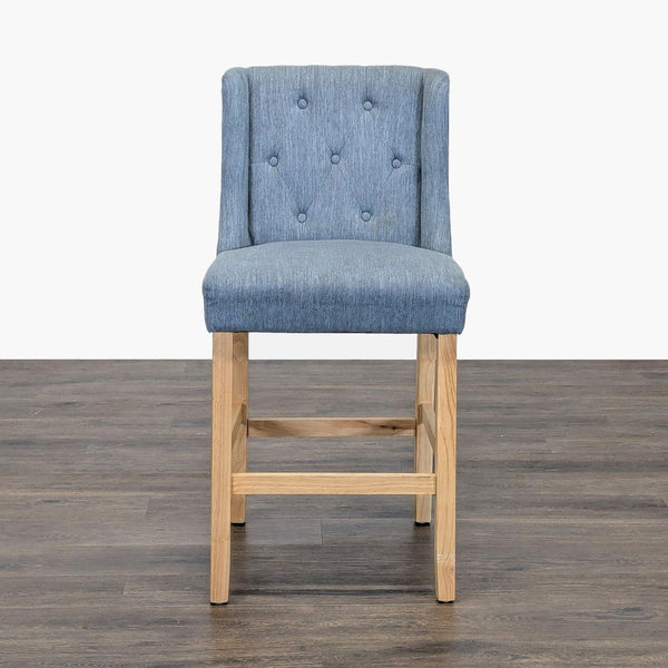 1. Blue upholstered Noble House Home stool with button-tufted back and wooden legs, placed on a dark floor.