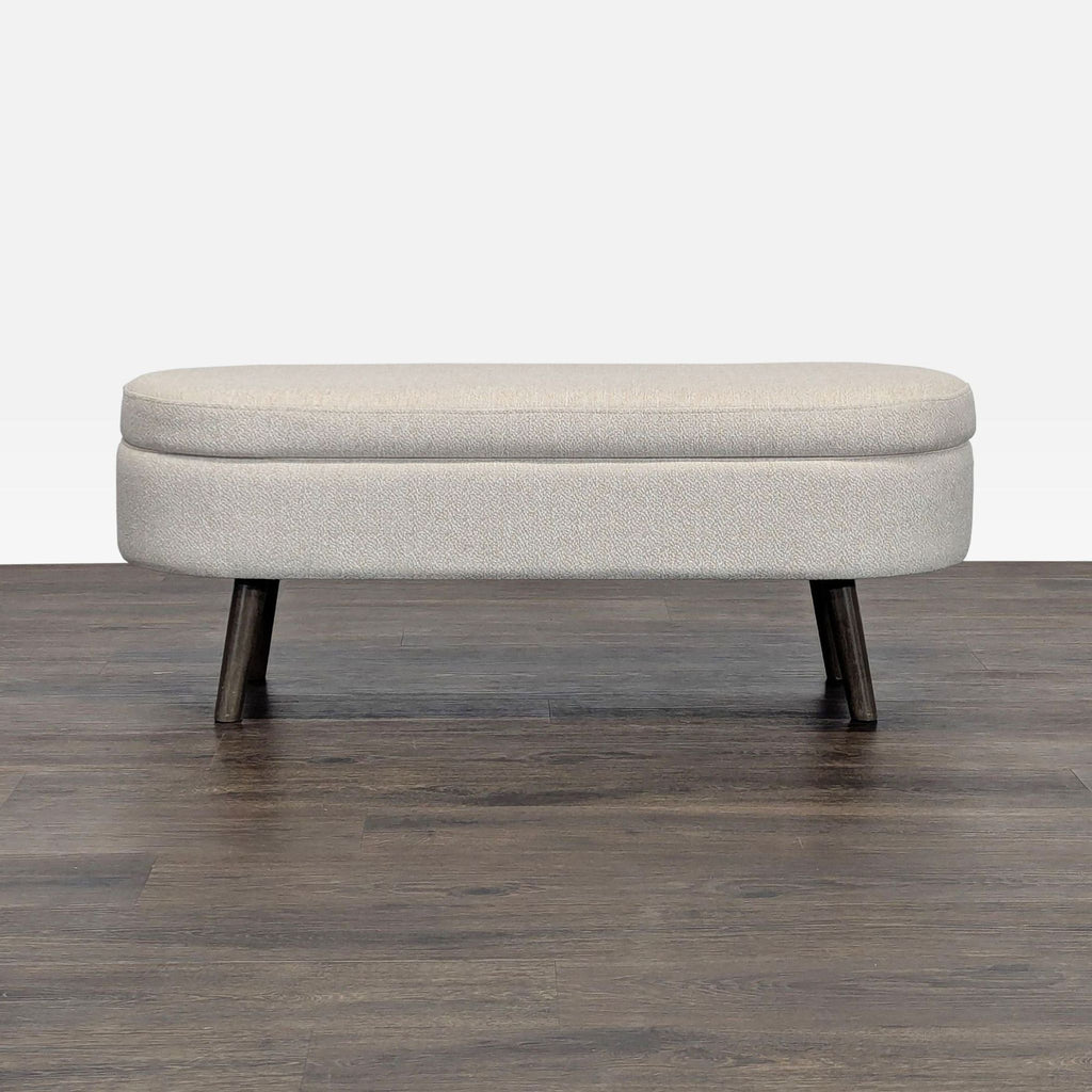 1. Modern beige upholstered bench ottoman from Walmart with dark wooden legs on a wood floor, closed view.