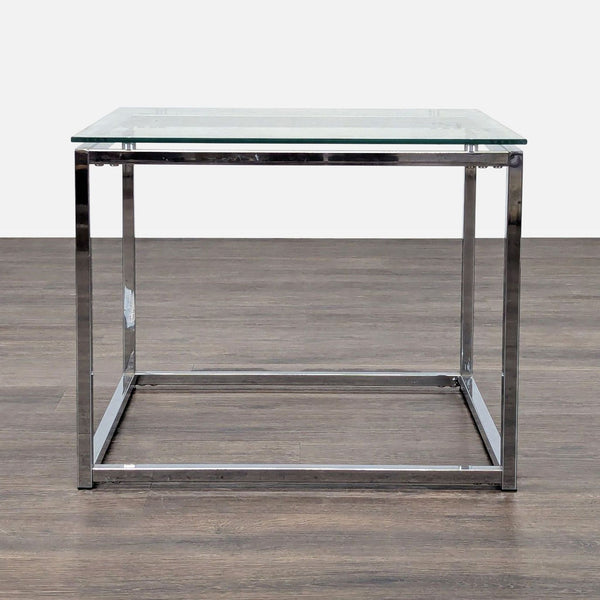 1. Reperch end table with a clear glass top and minimalist chrome metal frame, shown on wooden flooring.