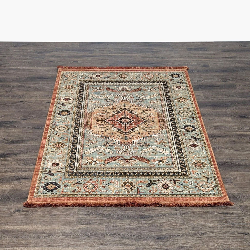 1. Reperch rug with a classic medallion design in rust, beige, and blue, shown on a wood floor.