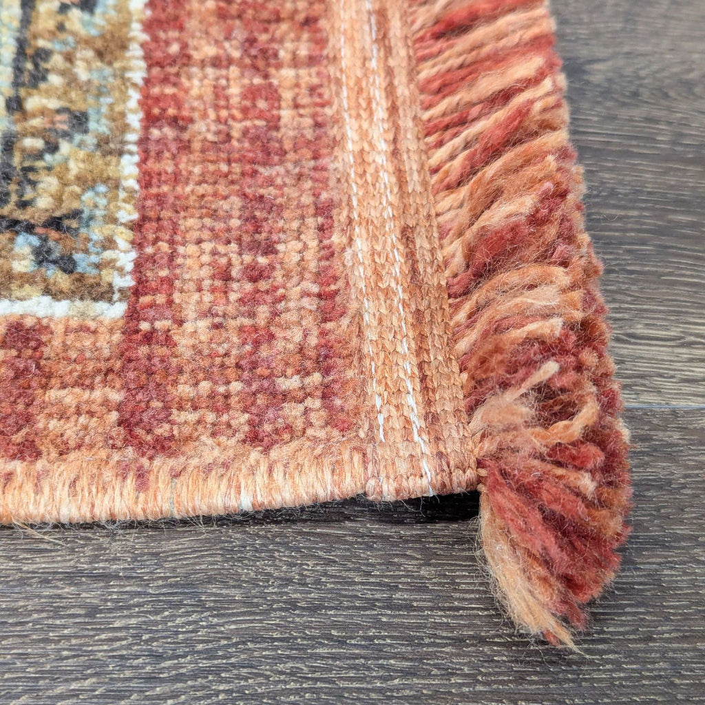 3. Edge detail of the Reperch rug, highlighting soft rust fringe and durable woven fibers.