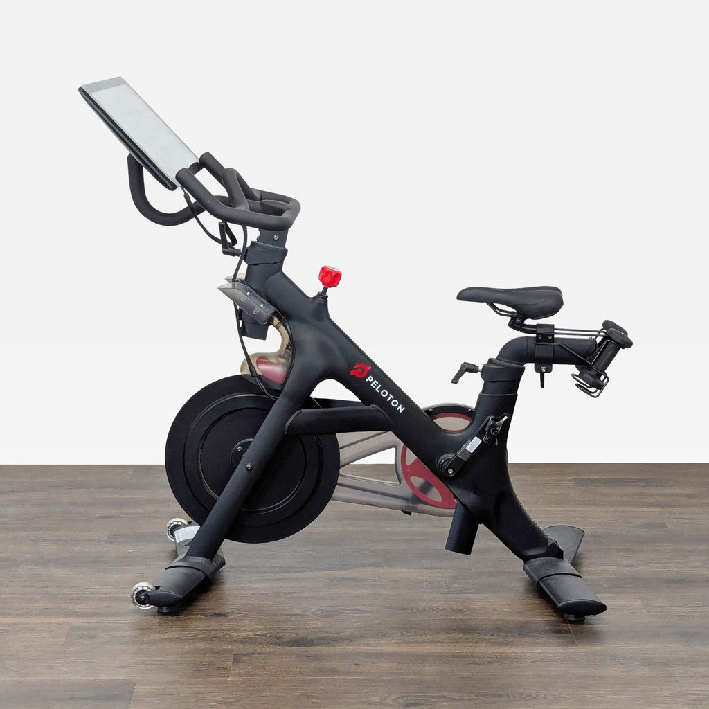 2. Side view of a Peloton exercise bike featuring a touchscreen and indoor cycling design.