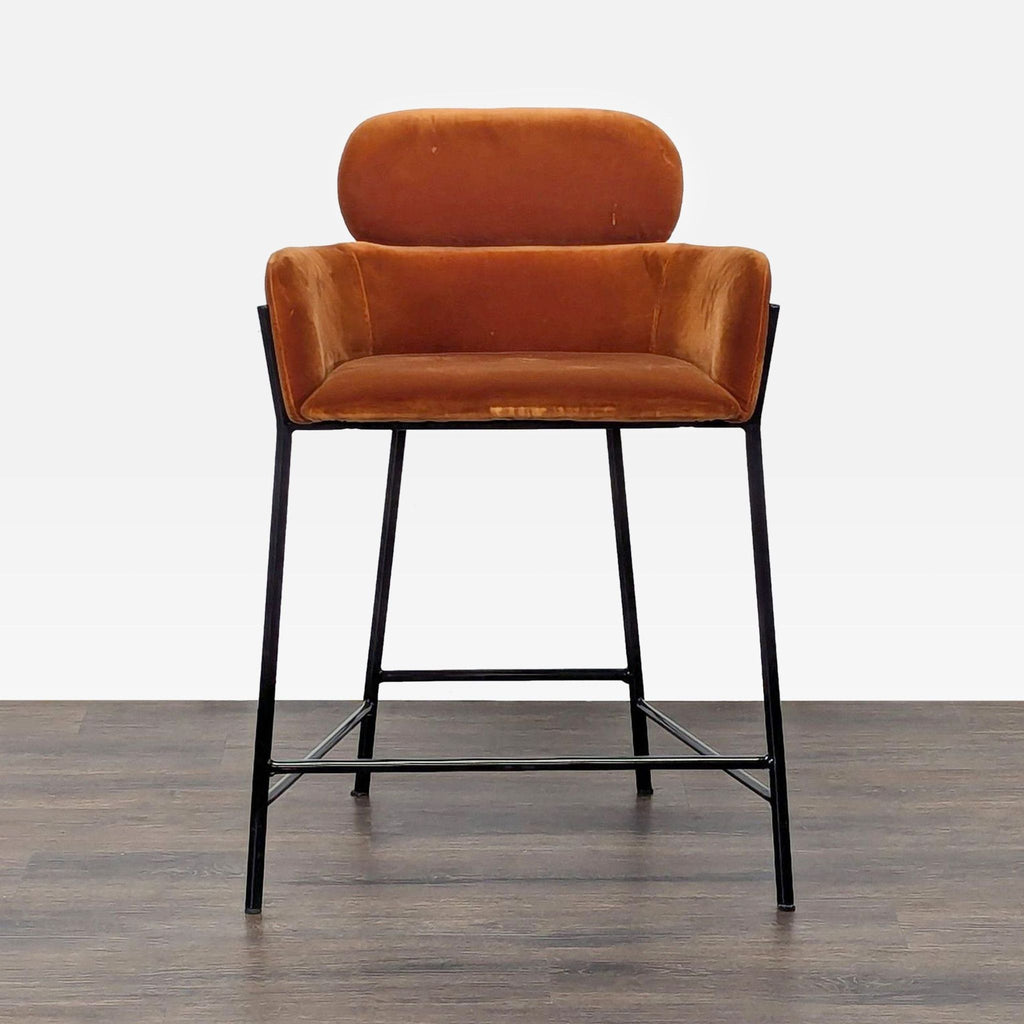 1. Front view of a CB2 velvet-upholstered stool with two-tier design and black iron base on wood floor.  