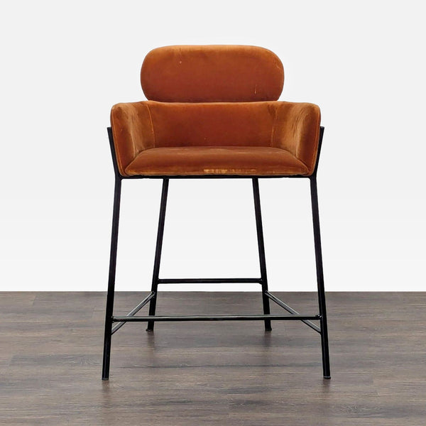 1. Front view of a CB2 velvet-upholstered stool with two-tier design and black iron base on wood floor.  