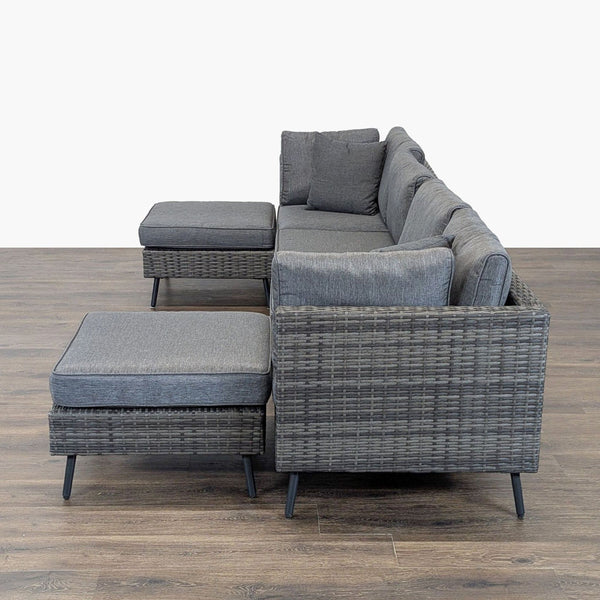 1. Side view of a Reperch woven rattan sectional set with gray cushions in good condition on wooden flooring.