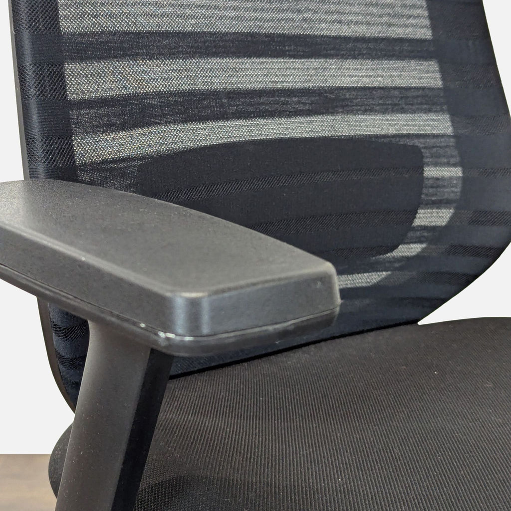3. Black mesh backrest and armrest detail of a Branch brand office chair.