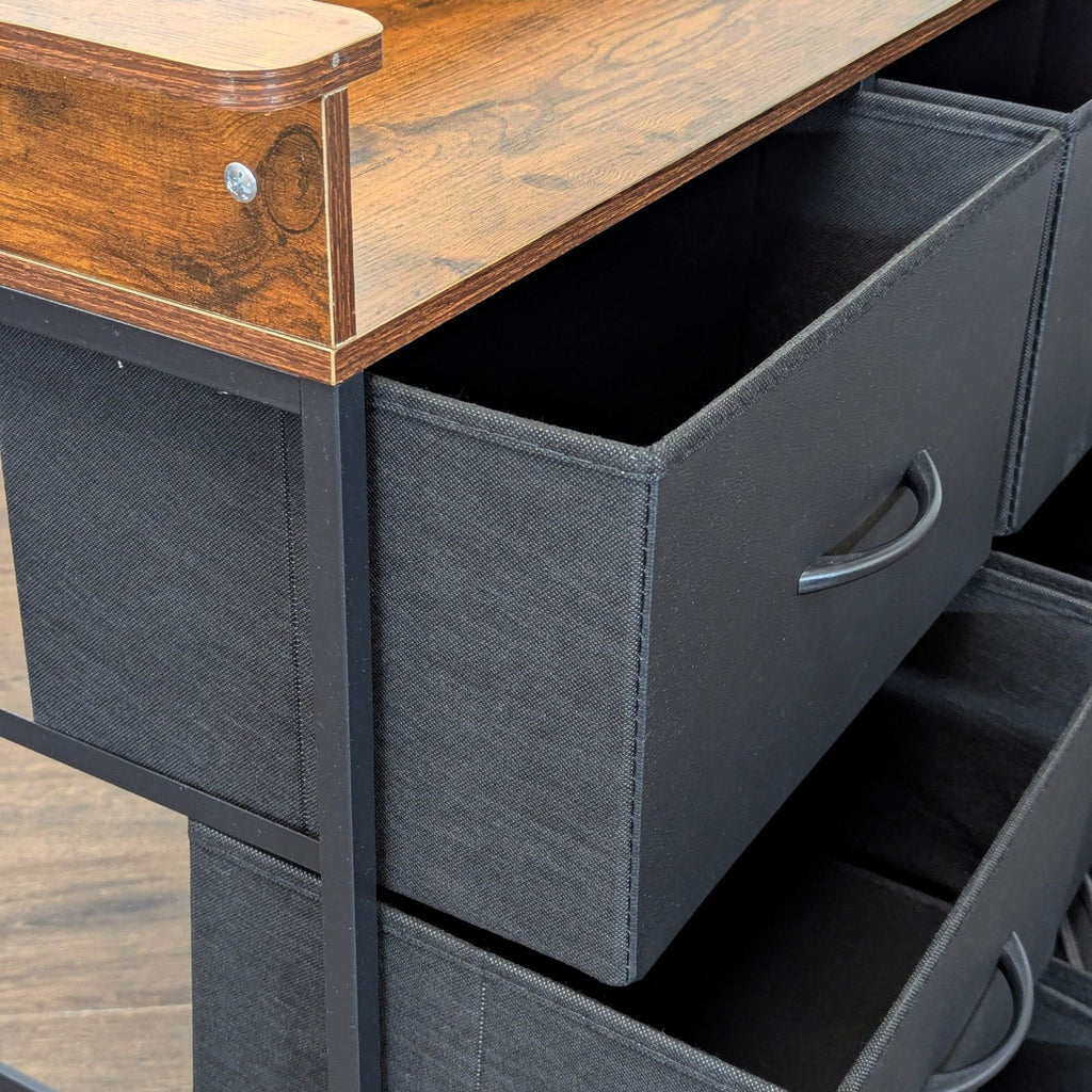 2. Close-up of the Reperch credenza’s corner, showing the textured wooden top and open black fabric drawers.