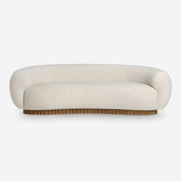 Front view of a Lulu and Georgia 3-seat sofa with curved shape, cream textured upholstery, and wooden base.  