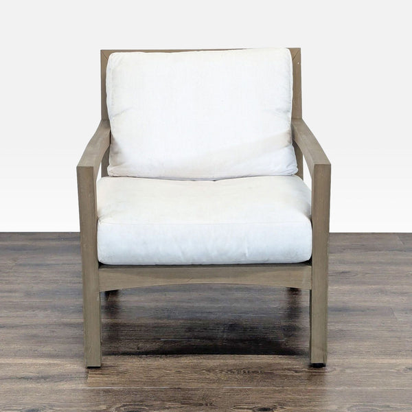 1. Front view of a Pottery Barn chair with a wooden frame and removable white cushions, perfect for outdoor use.