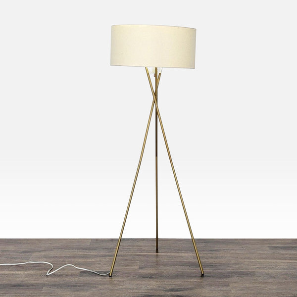 West Elm tripod floor lamp with gold base and beige drum shade, ideal for modern living spaces.