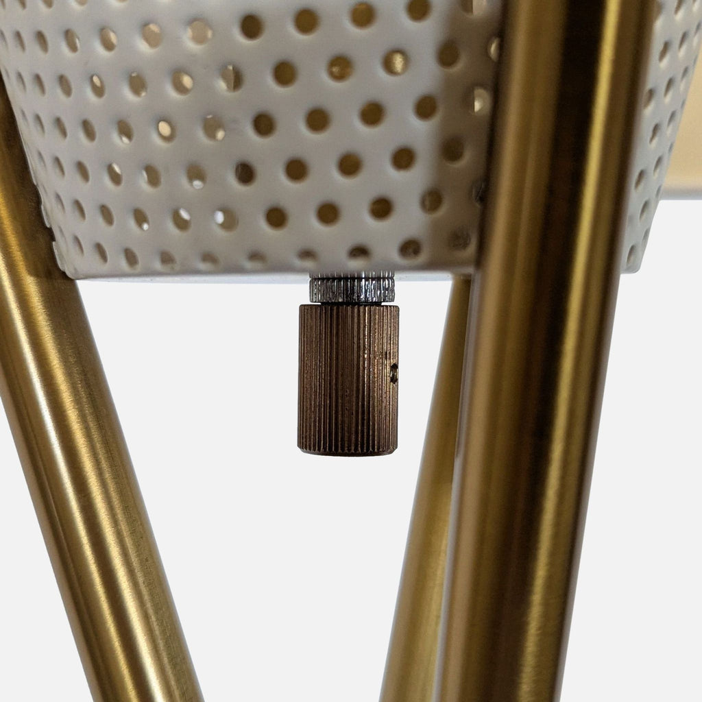 3. Detail of a brass lamp frame and perforated shade with a textured rotary switch, from West Elm Lighting.