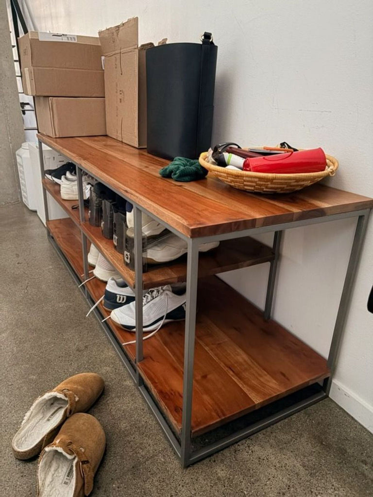 2. Side view of Reperch Entertainment Center, displaying shoes, boxes, and a basket on wood shelves.
