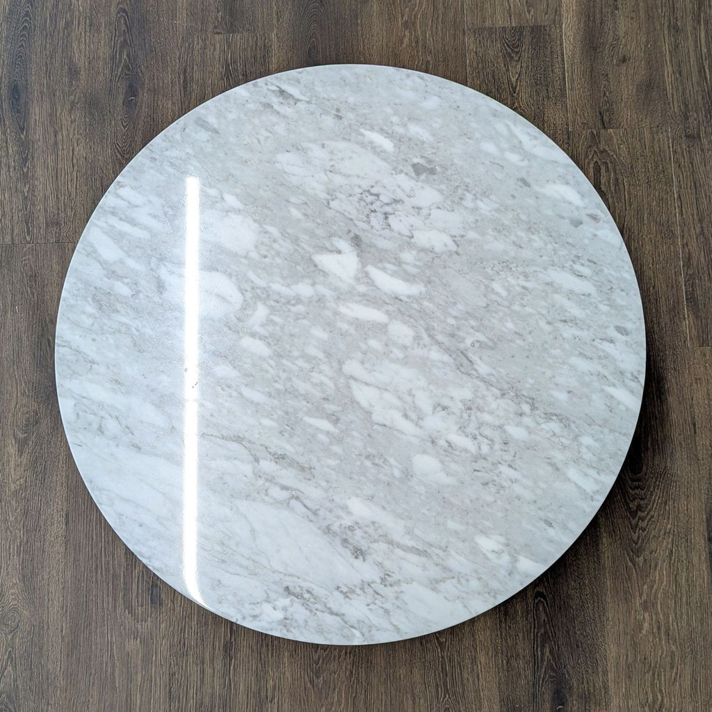 2. Top-down view showing the round, white marble surface of the Article coffee table.  