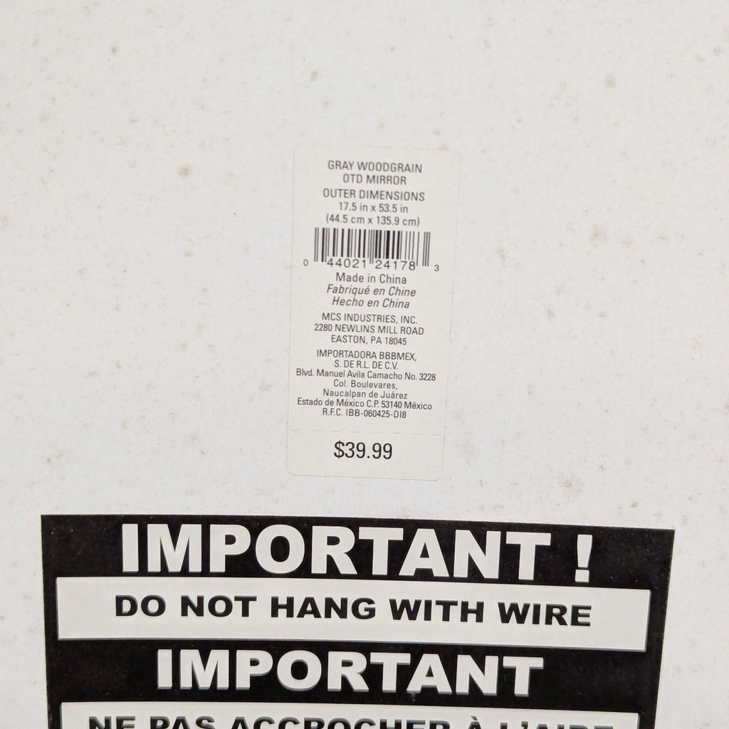 2. Close-up of the mirror's back label showing dimensions, brand MCS, price $39.99, and hanging instructions.