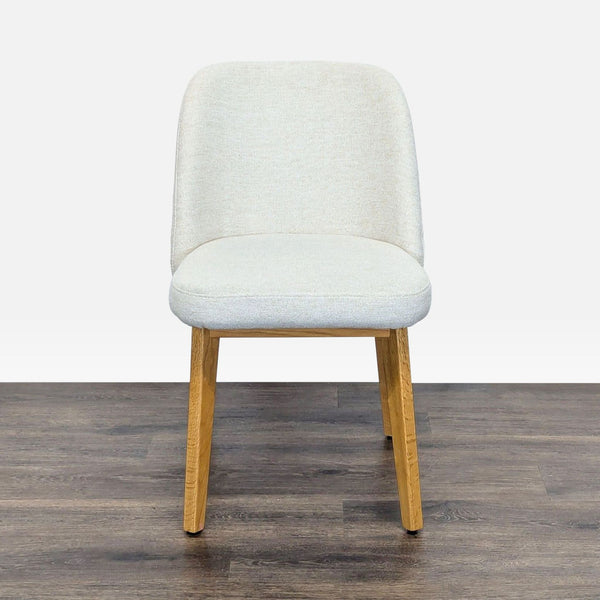 1. Front view of Article Dining Chair with oak wood legs and Camilla ivory padded seat and back.