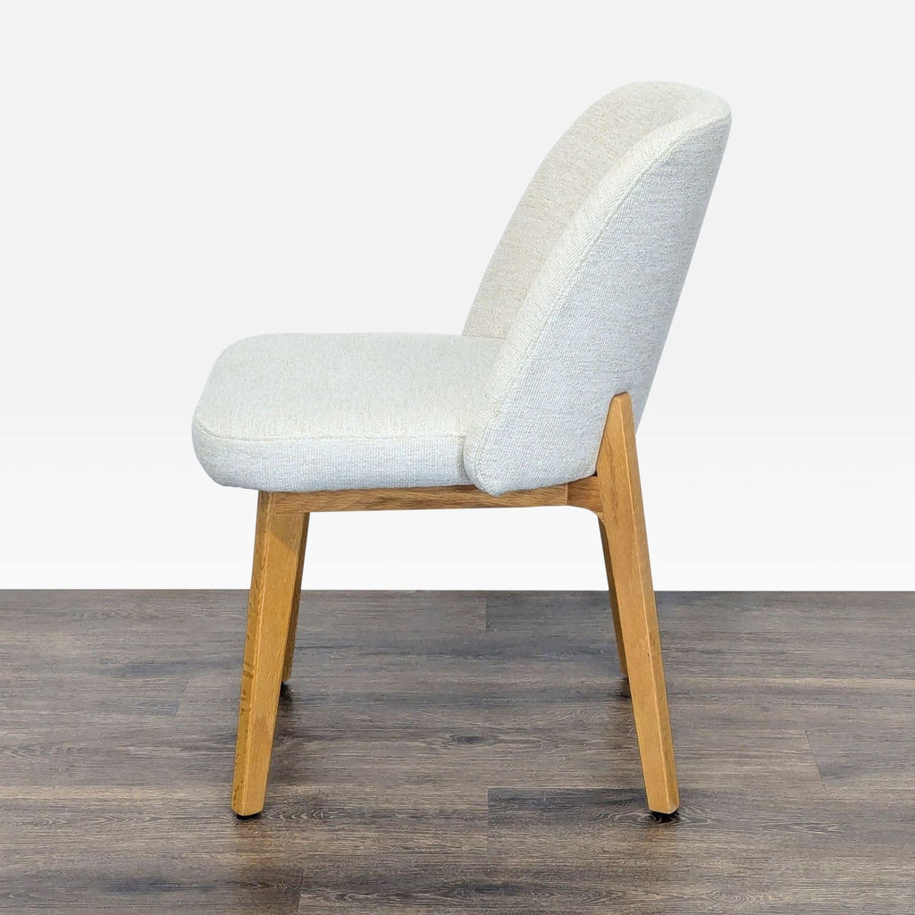 3. Side profile of Article Dining Chair, featuring padded Camilla ivory seat and oak frame.