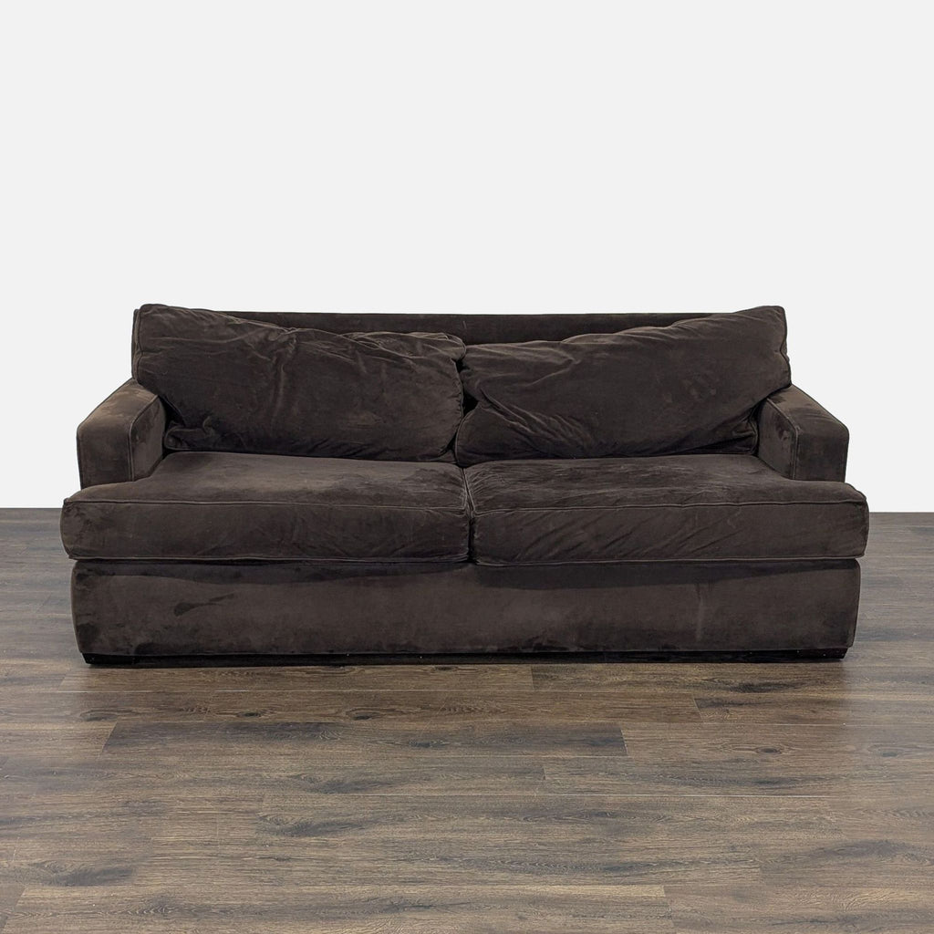 3. Full view of brown Macy’s 3-seat sofa with two seat cushions and two back pillows on wood floor.