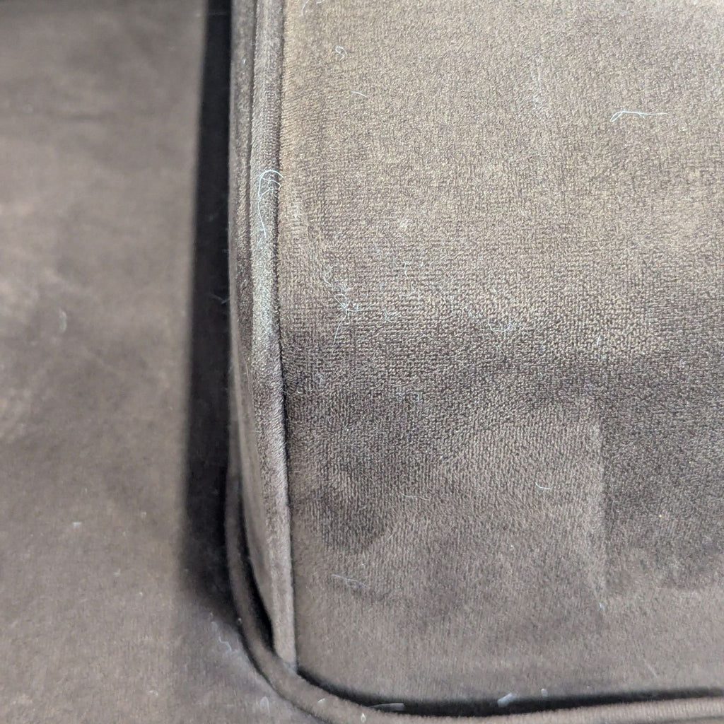 1. Close-up of brown Macy’s 3-seat sofa armrest, showing textured fabric and light lint.