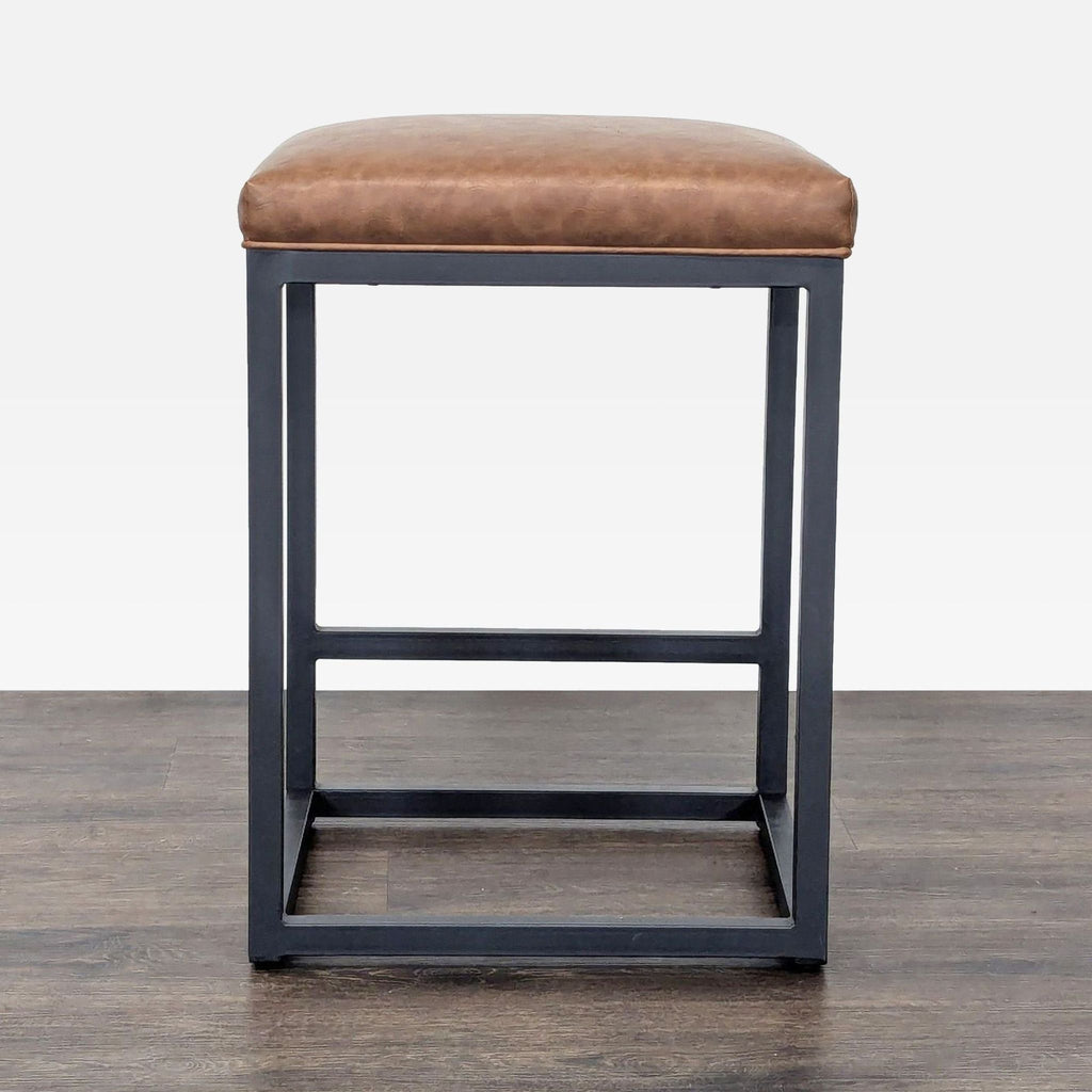 2. Modern Bluefyn stool featuring a brown faux leather top and sturdy metal base with footrest, straight-on view.  